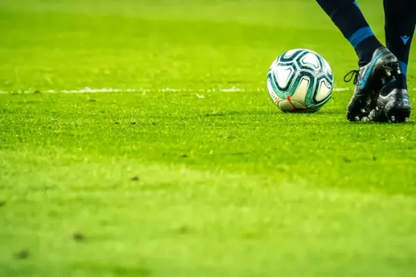 Football player resting his foot on a football