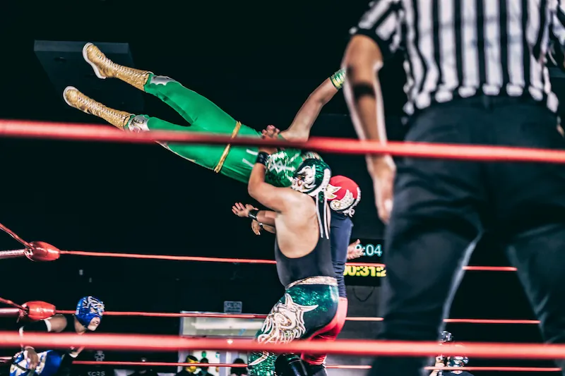 Lucha Libre wrestler performing a throw in the ring at Arena México